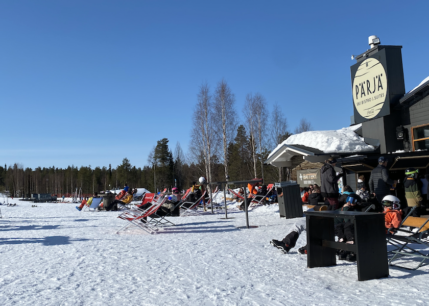 Laskettelijat nauttivat auringosta Pitkäperjantaina takarinteiden Pärjä Ski Bistron terassilla.