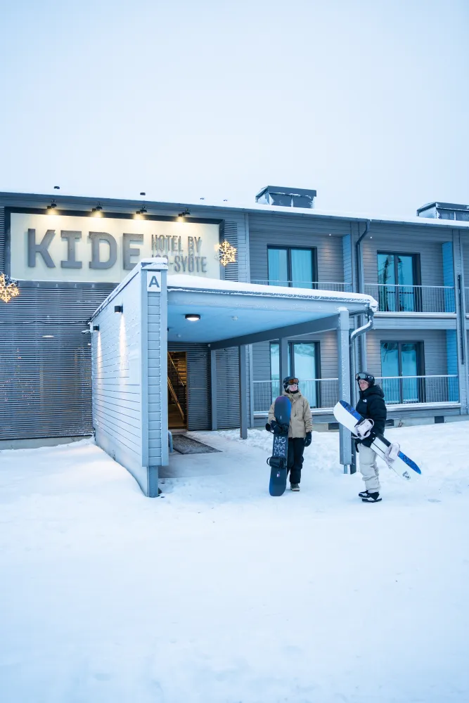 Kide hotellin edustalla laskettelijoita