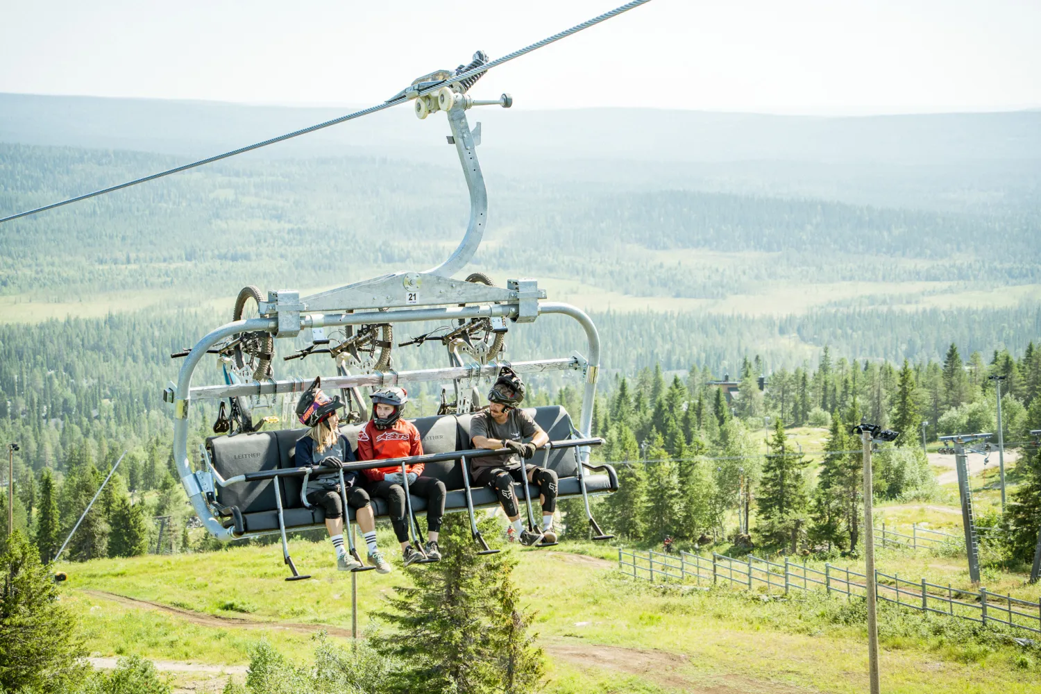 Kolme pyöräilijää tuolihississä