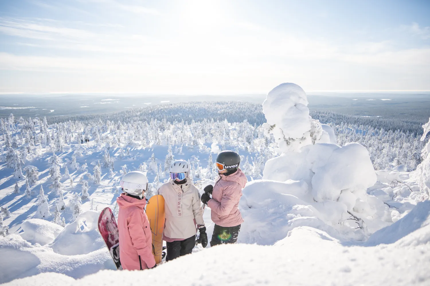 Tunturin huipulla laskettelijoita aurinkoisena päivänä 