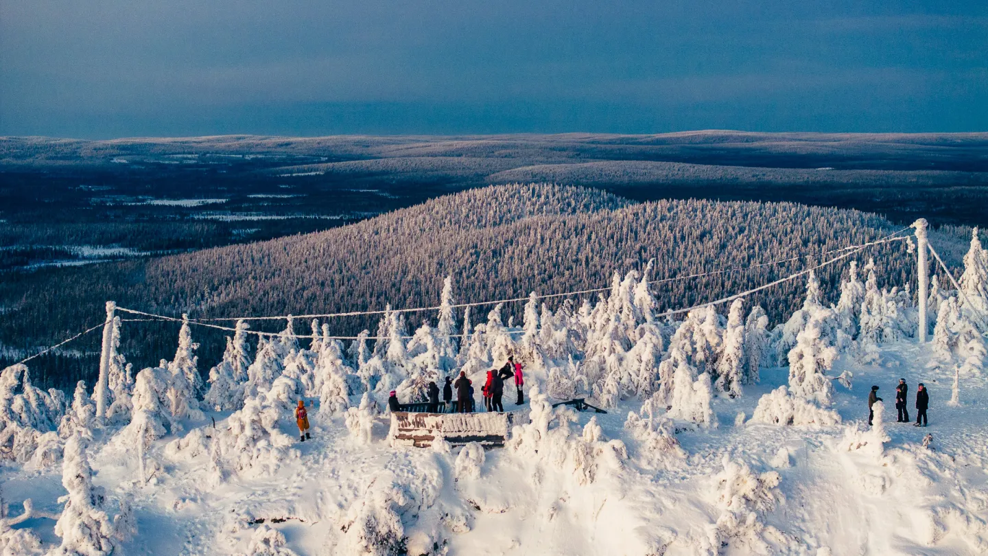 Ihmisiä Iso-Syötteen huipulla auringonlaskussa