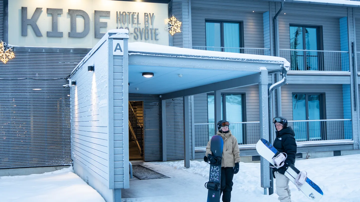 Kide hotellin edustalla laskettelijoita
