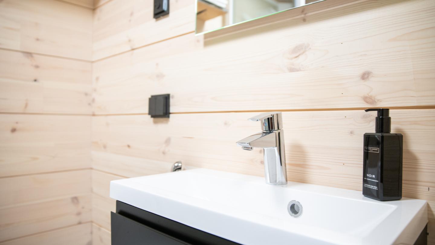 Tunturilaakson siisti puuseinäinen kylpyhuone