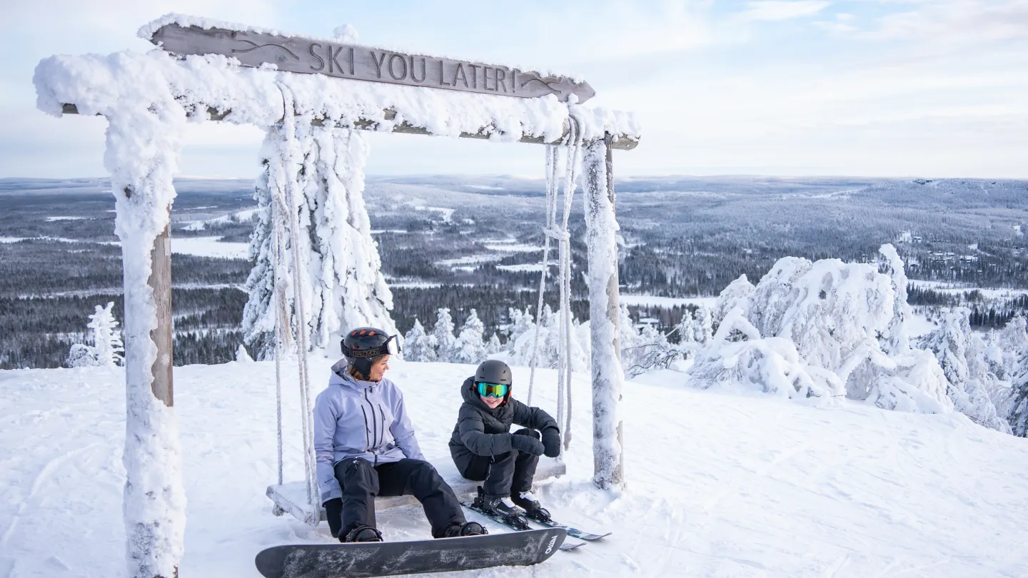 keinulla 2 laskijaa, lapsi ja vanhempi